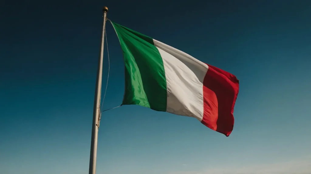 The Italian flag waving in the wind against a bright blue sky, symbolizing Italy’s culture and language.